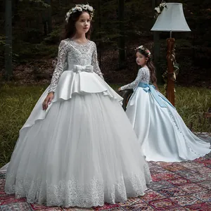 Detail of ivory lace embroidery and satin bow on luxury long-sleeved girls princess gown