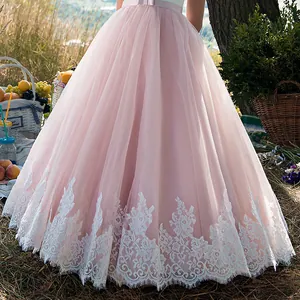Dettaglio della gonna in tulle rosa a strati con ricamo floreale in pizzo bianco sui bordi