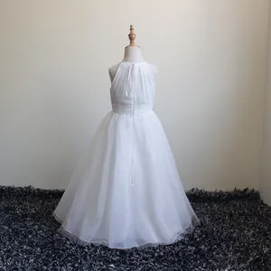 Dettaglio dell'abito da cerimonia bianco in chiffon con corpetto a pieghe e gonna in tulle