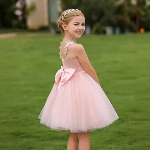 Detailed back view of pink flower girl dress with a large satin bow and layered tulle