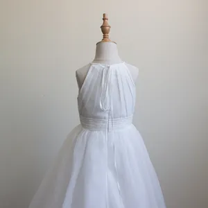 Dettaglio della gonna in tulle a strati e corpetto in chiffon dell'abito da bambina bianco