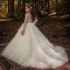 Ivory lace flower girl dress with a trailing tulle skirt and satin back bow in forest
