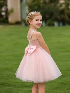 Pink lace flower girl dress with a large back bow and tulle skirt for weddings