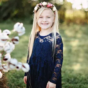 Detalle de vestido de encaje azul oscuro para niña con manga larga y flores