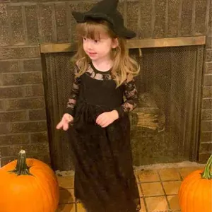 Detalle del disfraz de bruja para niña con vestido de encaje y sombrero de punta a juego