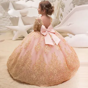 Dettaglio dell'abito da bambina con fiocco in raso rosa e pizzo dorato sulla schiena