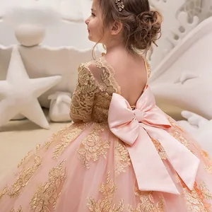 Dettaglio dell'abito da bambina rosa con schiena scoperta e grande fiocco decorativo in raso