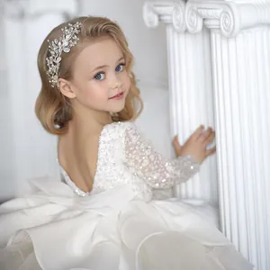Exquisite back detail of kids lace dress featuring a large mesh bow and silver floral headband