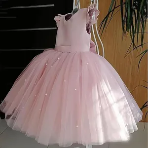 Detail of pink girls tulle dress featuring layered mesh skirt and pearl embellishments