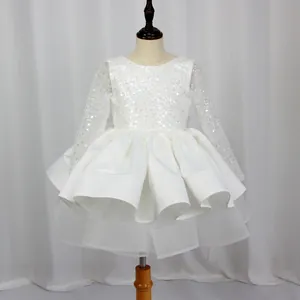 Close-up of white girls princess dress featuring sequined bodice and tiered mesh skirt