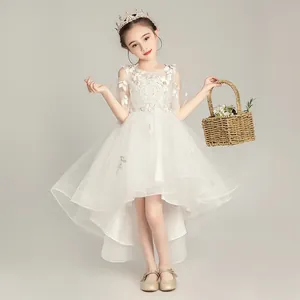 Detalle de vestido blanco de encaje para niña con bordados y falda de tul