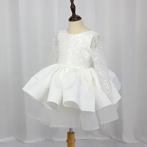 Detail of child's white princess dress with sequins, long sleeves, and puffy satin skirt