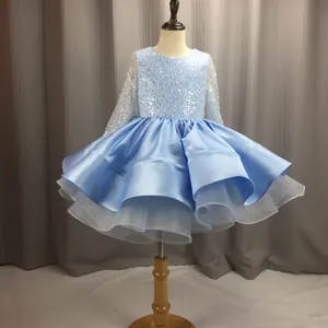 Detail of light blue girls ball gown showing sequined bodice and layered satin tiered skirt