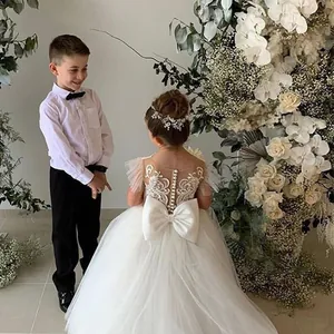 Détail de robe de demoiselle d'honneur blanche avec broderie en dentelle et grand nœud