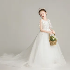 Detalle de vestido de princesa blanco para niña con bordados florales y cola larga de tul
