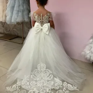 Détail de robe de demoiselle d'honneur blanche avec dentelle, perles et gros nœud