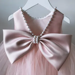 Pink girls floral princess dress with large satin bow and pearl beaded neckline detail