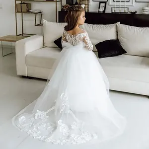 Detail of the white lace long sleeves and hollow back design on the girl's princess dress