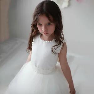 White sleeveless flower girl dress with pearl neckline and tiered tulle tutu skirt