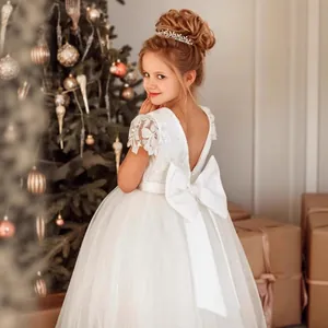 Détail de robe de demoiselle d'honneur blanche avec dos en V et grand nœud satiné
