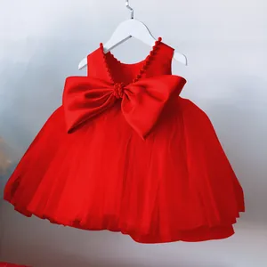 Detail of red flower girl dress featuring back satin bow and layered tulle skirt
