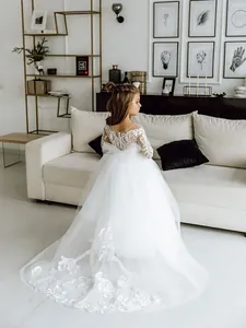 Elegant white lace long sleeve flower girl gown with layered tulle train and back bow