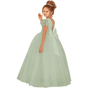 Détail de robe en tulle vert sauge avec haut en dentelle et grand nœud pour fille
