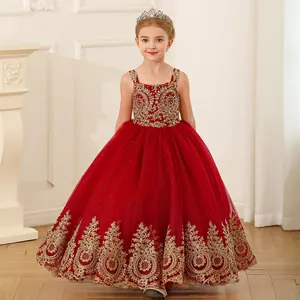 Détail de robe rouge pour fille avec broderies dorées complexes et jupon en tulle évasé