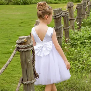 Detail of elegant white girl's dress with large satin bow and layered tulle back view