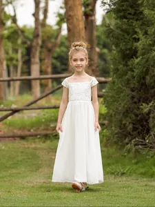 Detail van witte kant bloemenmeisjesjurk met blote schouders en gelaagde chiffon rok