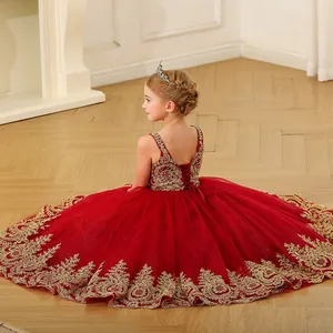 Détail d'une robe de soirée rouge foncé pour fille avec broderie dorée et jupon en tulle