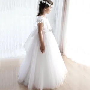 Gros plan du corsage en dentelle blanche et du nœud sur la robe de demoiselle d'honneur