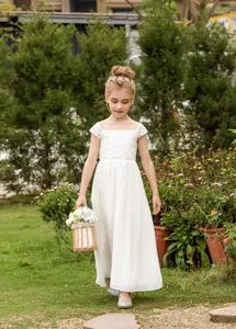 Detail van het witte kanten lijfje en de chiffon rok van een bloemenmeisje jurk voor kids