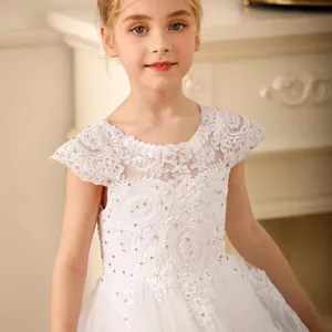 Close-up of white lace bodice with floral embroidery and sparkling rhinestones on girl dress