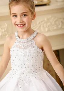 Detail of white girls lace dress with halter neckline and floral embroidery