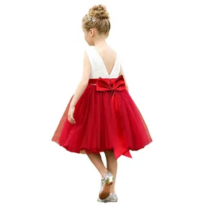 Vestido de encaje blanco para niña con escote en V y un gran lazo rojo y falda de tul