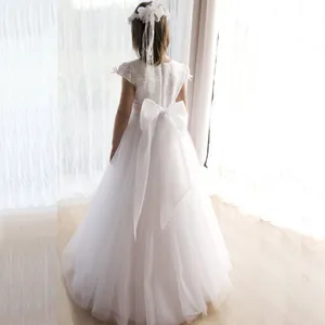 Vue détaillée du dos d'une robe de cortège en dentelle blanche avec un grand nœud en satin