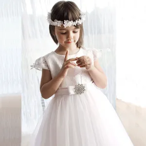 Détail du corsage en dentelle blanche et jupe en tulle avec ceinture à fleur en strass