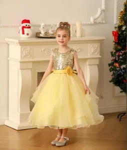 Detail of yellow flower sash and shimmering gold sequin bodice on a girl princess gown