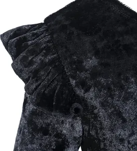 Detailaufnahme des schwarzen Samtkleides mit Rüschenärmeln und feiner Textur im Profil
