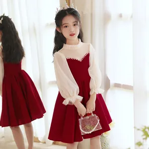 Dettaglio dell'abito da bambina in velluto rosso con maniche velate e paillettes d'oro