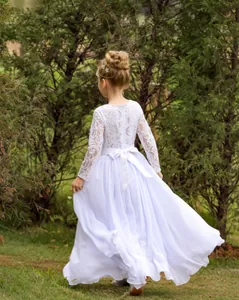 Vue arrière détaillée d'une robe de fille en dentelle blanche à manches longues avec nœud en soie