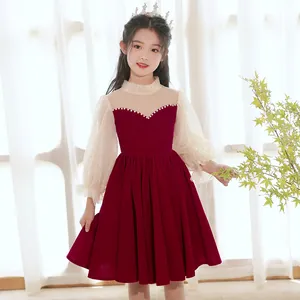 Dettaglio dell'abito in velluto rosso vino per bambina con perle e maniche in mesh