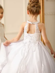 White lace flower girl dress with halter neckline, back bow, and tiered tulle skirt