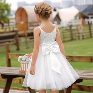 Abito bianco da damigella in pizzo con grande fiocco di raso e gonna di tulle