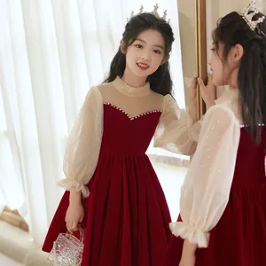 Dettaglio dell'abito in velluto bordeaux per bambina con colletto di perle e maniche in rete