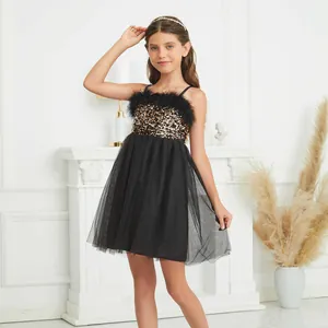 Detail of girls' black sequin party dress with delicate feather trim and layered mesh skirt
