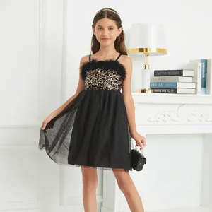 Detail of girls' black sequined dress featuring soft feather trim and layered tulle skirt