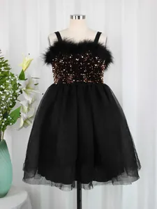 Detail of girls' black dress featuring sequins, feather trim and multilayered tulle skirt