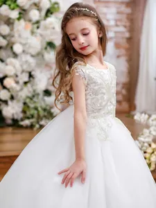 Detailed close-up of silver sequin embroidery on a white lace flower girl dress
